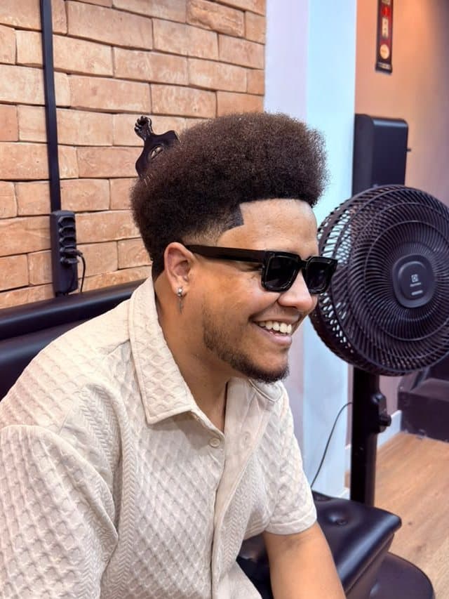 Cliente com black power e degradê na Barbearia Luma